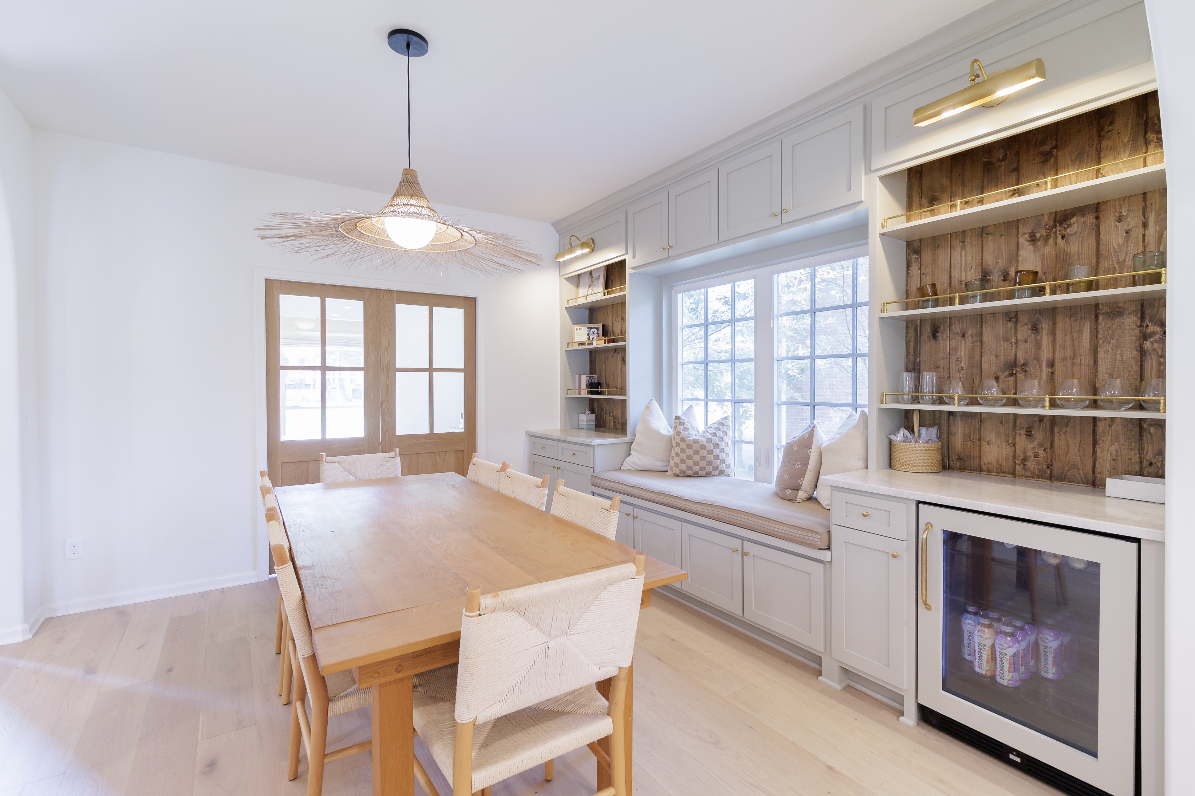 Bright dining area with a wooden table, chairs, and built-in window seat