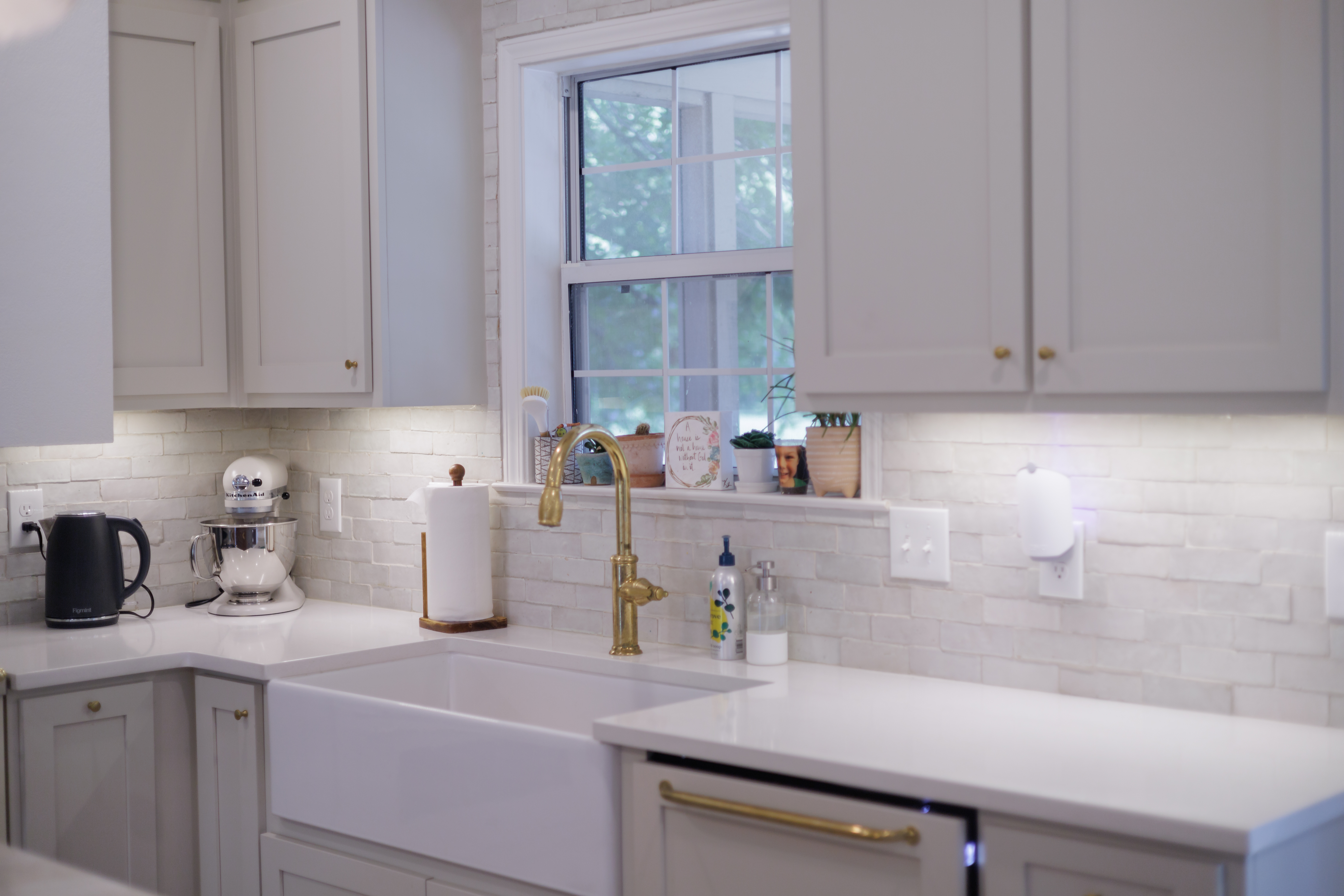 Modern kitchen with white subway tile backsplash and brass fixtures, bright and clean